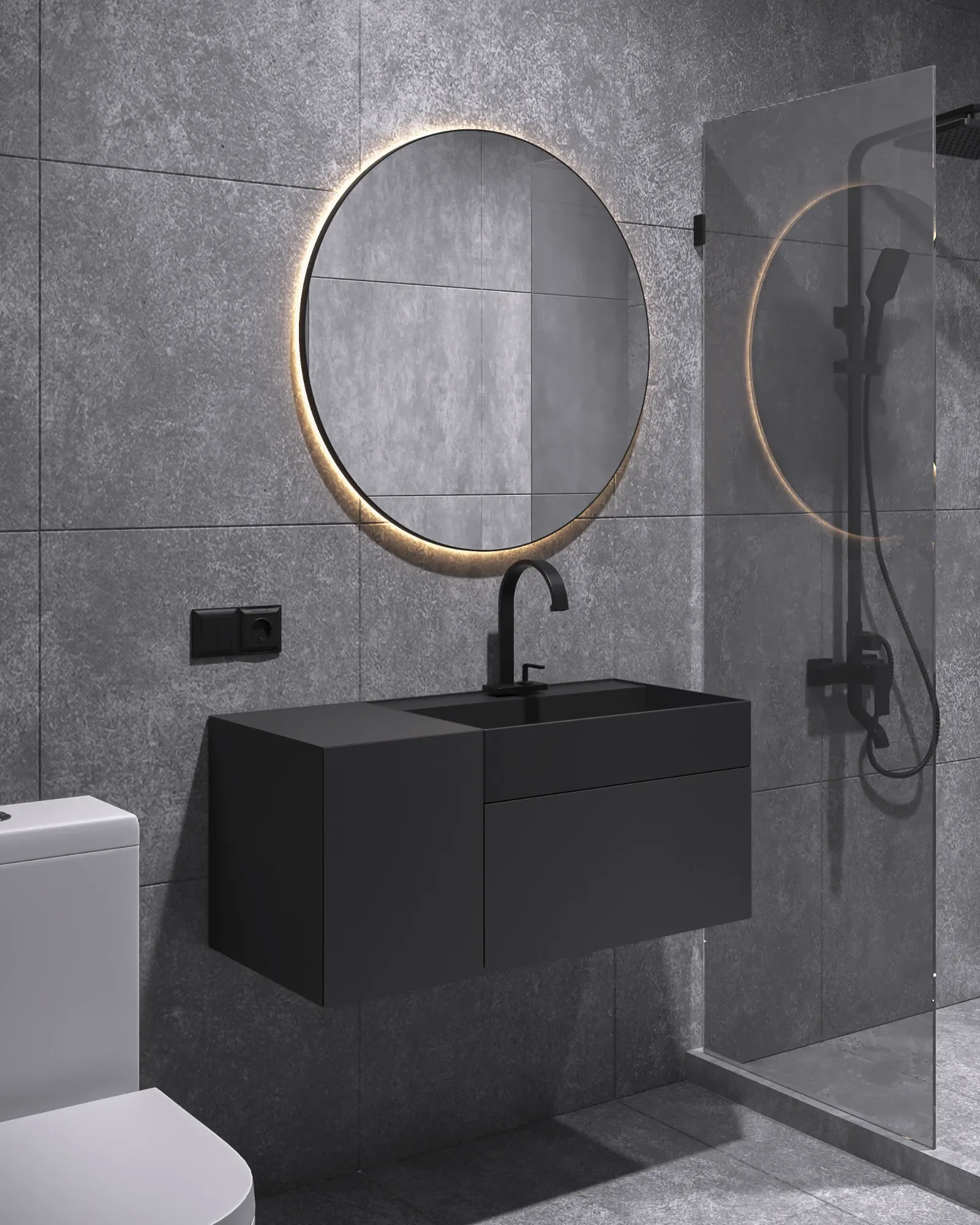 Wet room in charcoal concrete-effect tiles with a backlit round mirror, matt black vanity and a walk-in shower behind glass.