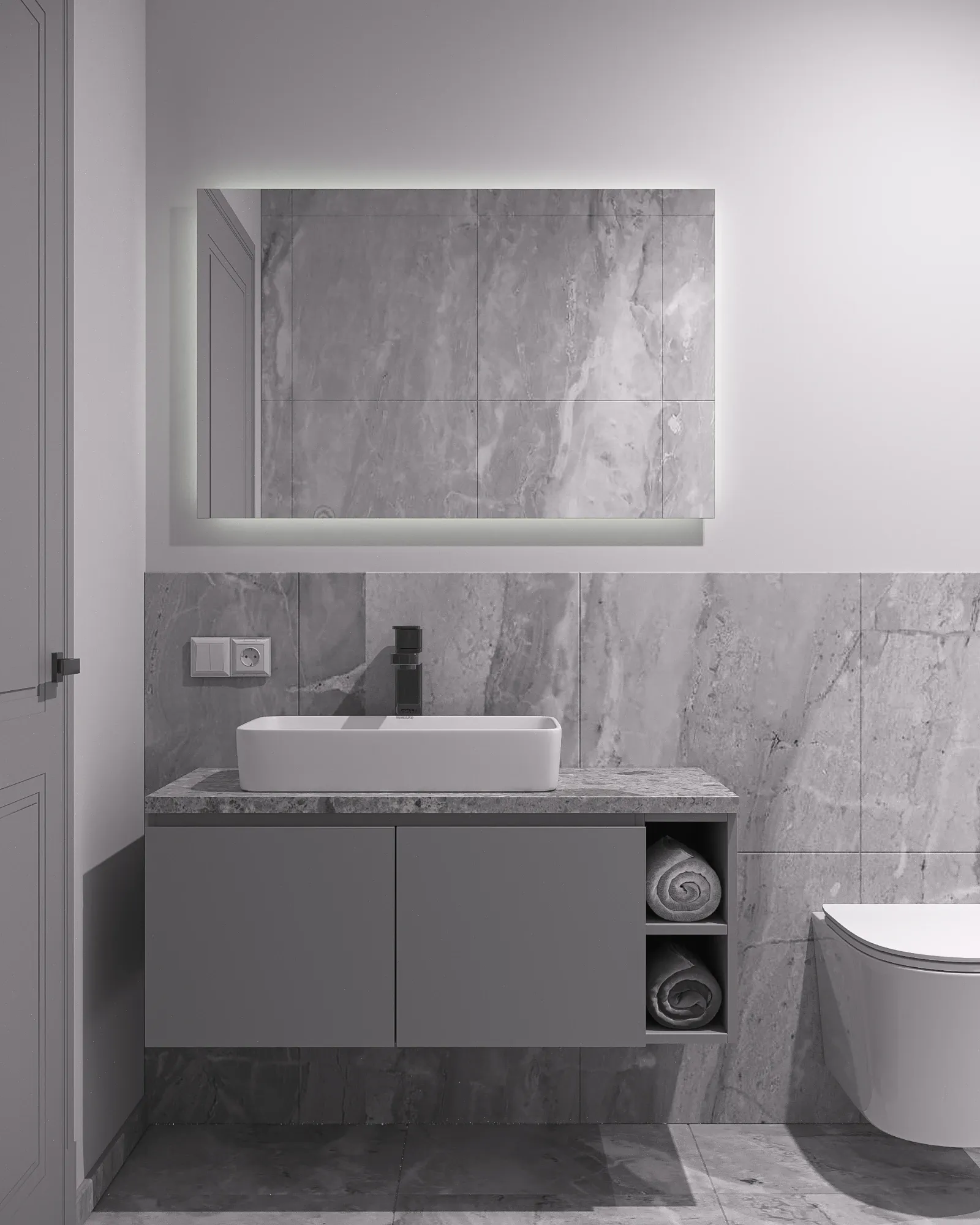 Family bathroom in pale grey marble with a backlit mirror, white counter-top basin on a stone vanity and open towel shelving.